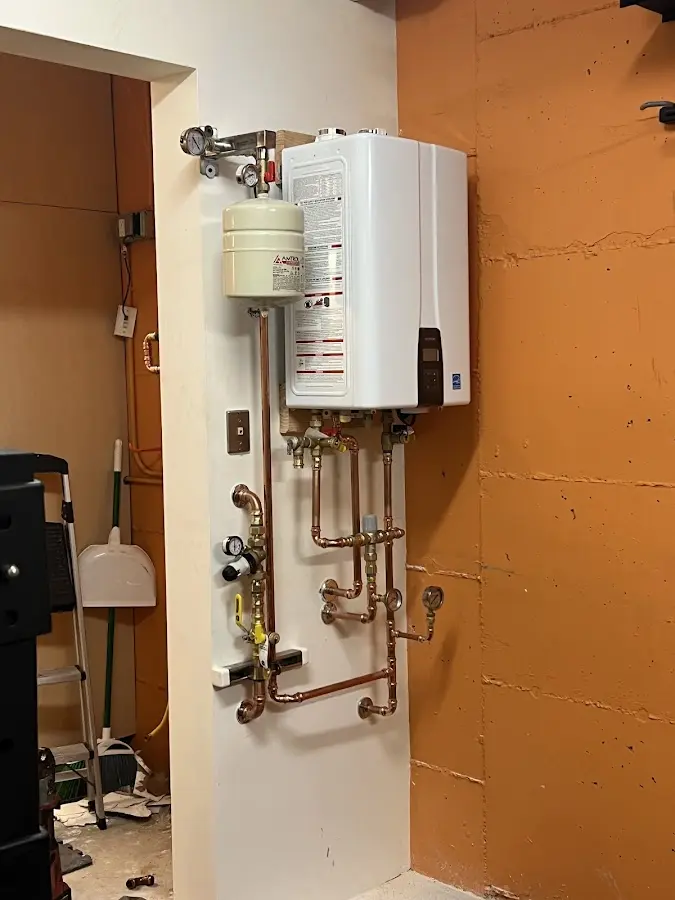 Plumbing technician inspecting water heater connections in Pilesgrove